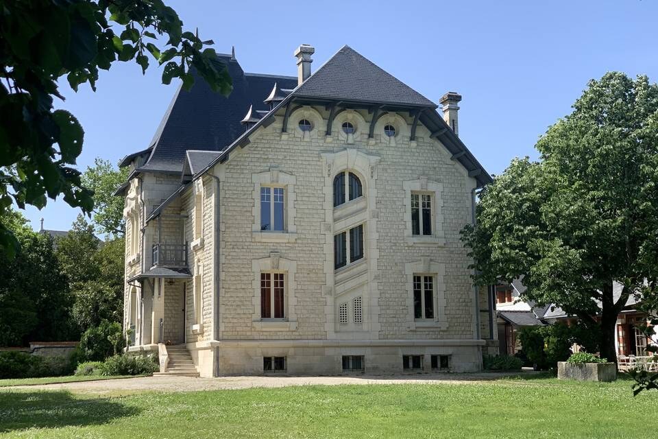 La Villa Nymphea vue du parc, la maison de pierre entière et sa pelouse